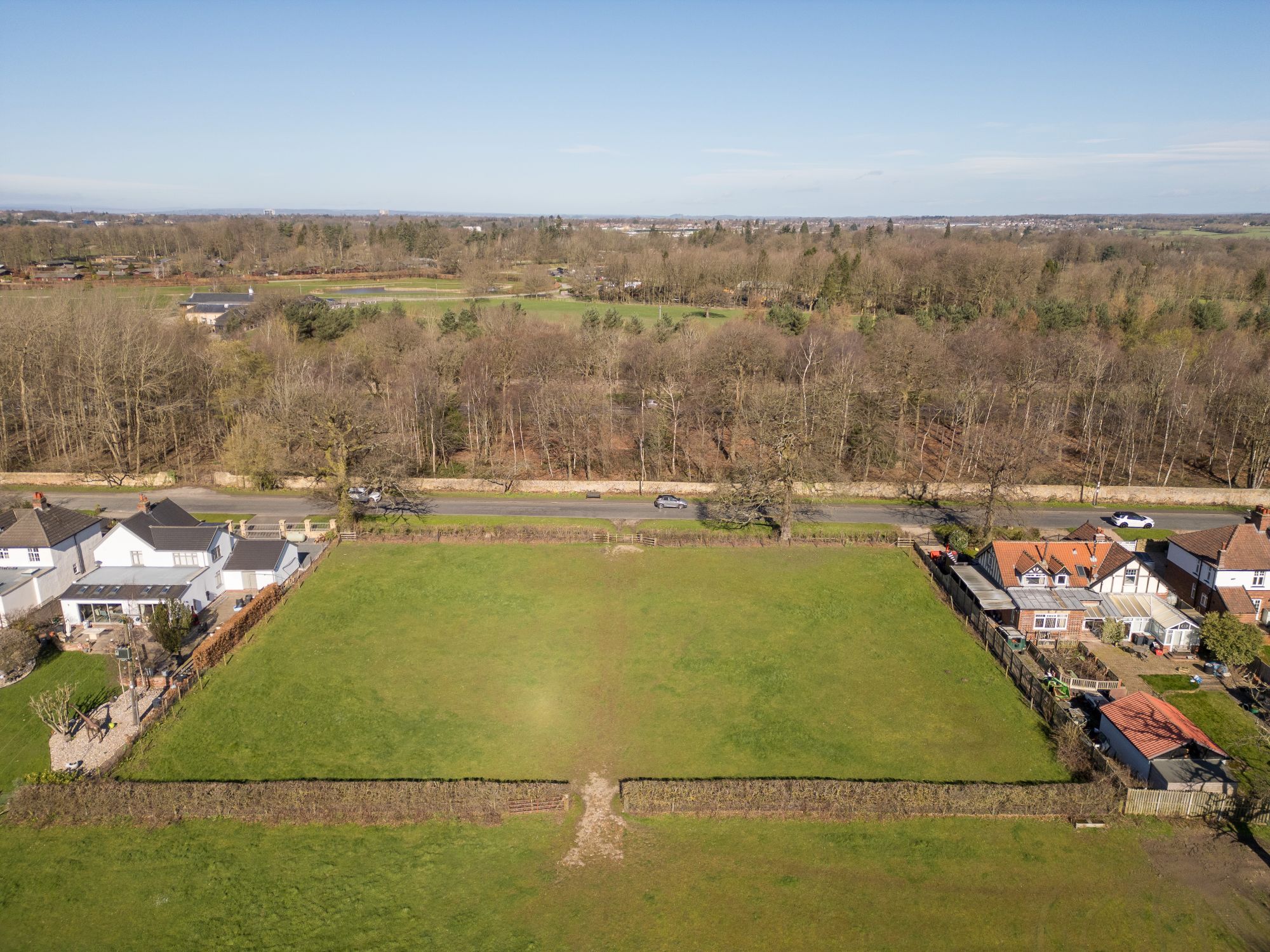A picture of the 0.8 acre Development Site. A field surrounded by hedges with properties to either side and open fields to the rear.
